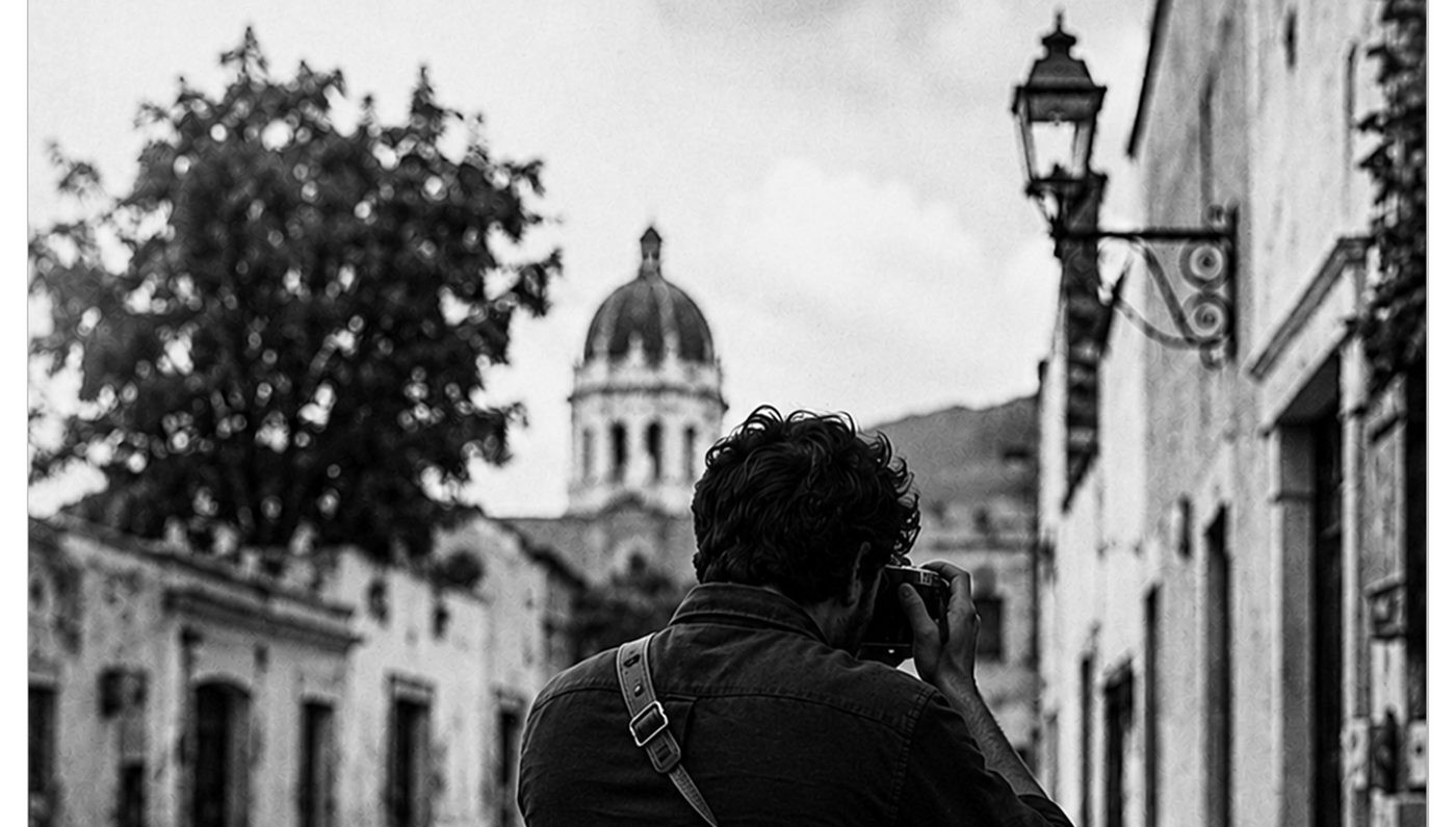 Fotógrafo encuadrando una calle de Tequisquiapan con la cúpula al fondo